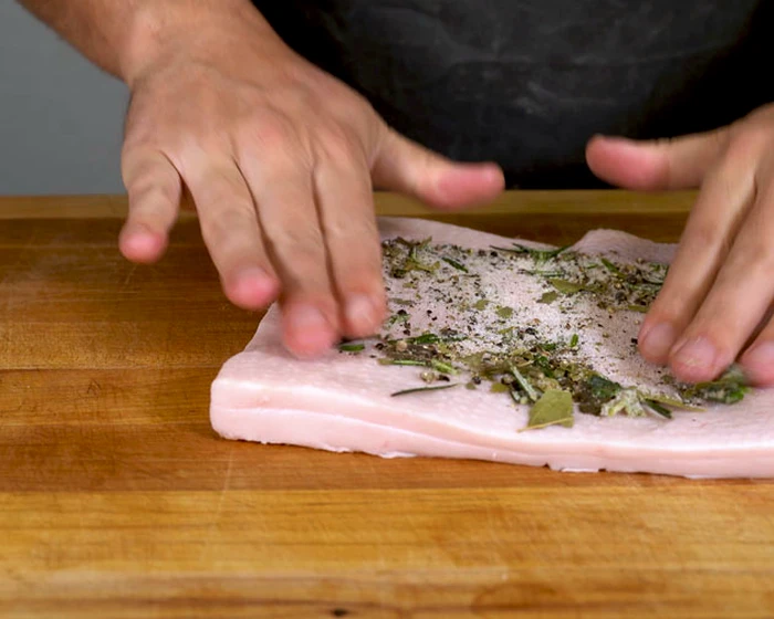Rubbing lardo with spices by hand