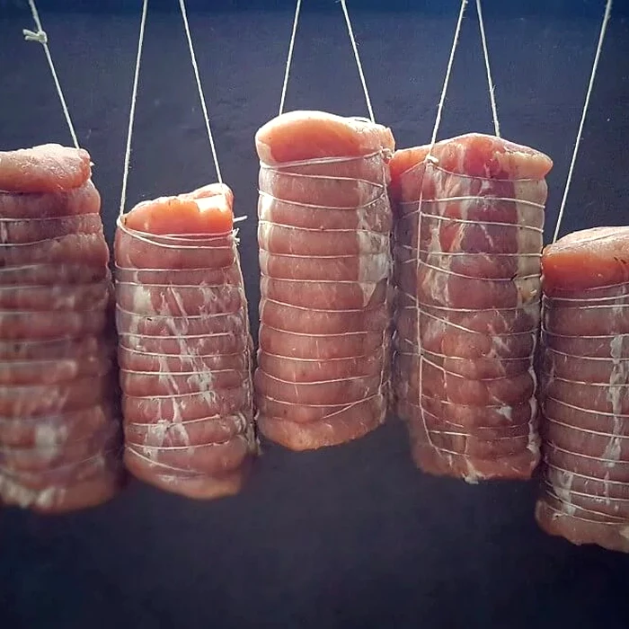 Lachsschinken hanging in the smoker for cold smoking
