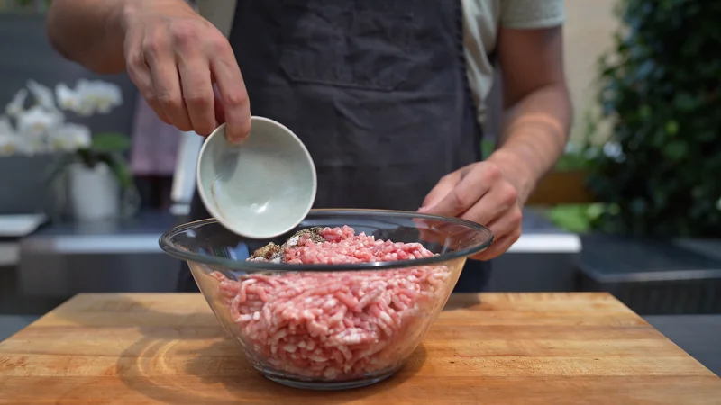 Adding the spices to the sausage meat