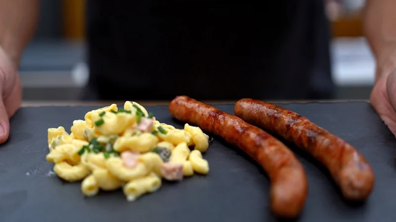 Grilled sausages served with pasta salad