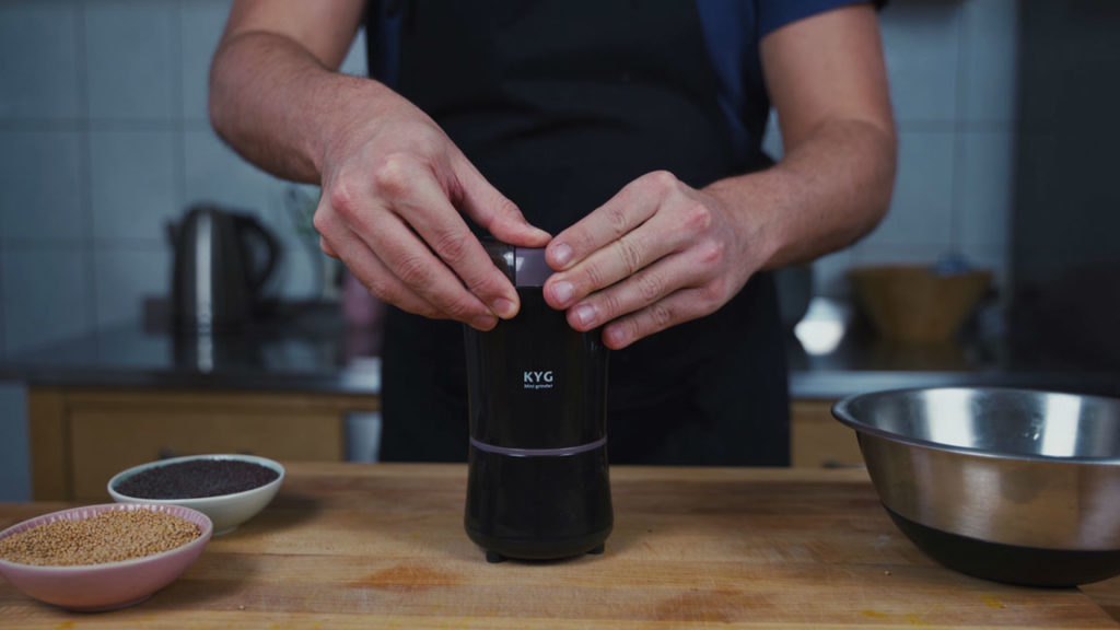 Grinding mustard seeds finely in a spice grinder