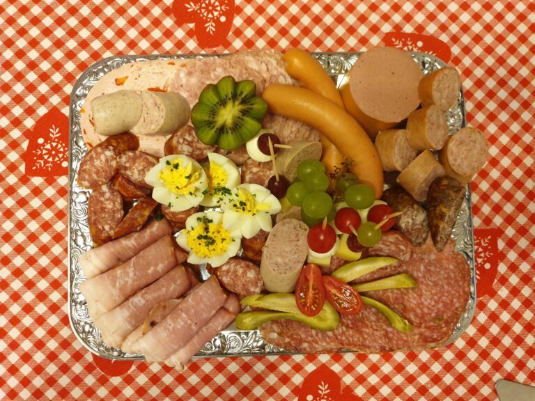 A cold cut platter with assorted sausages and accompaniments