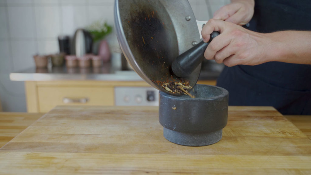 Coarsely crushing corned beef spices in a mortar