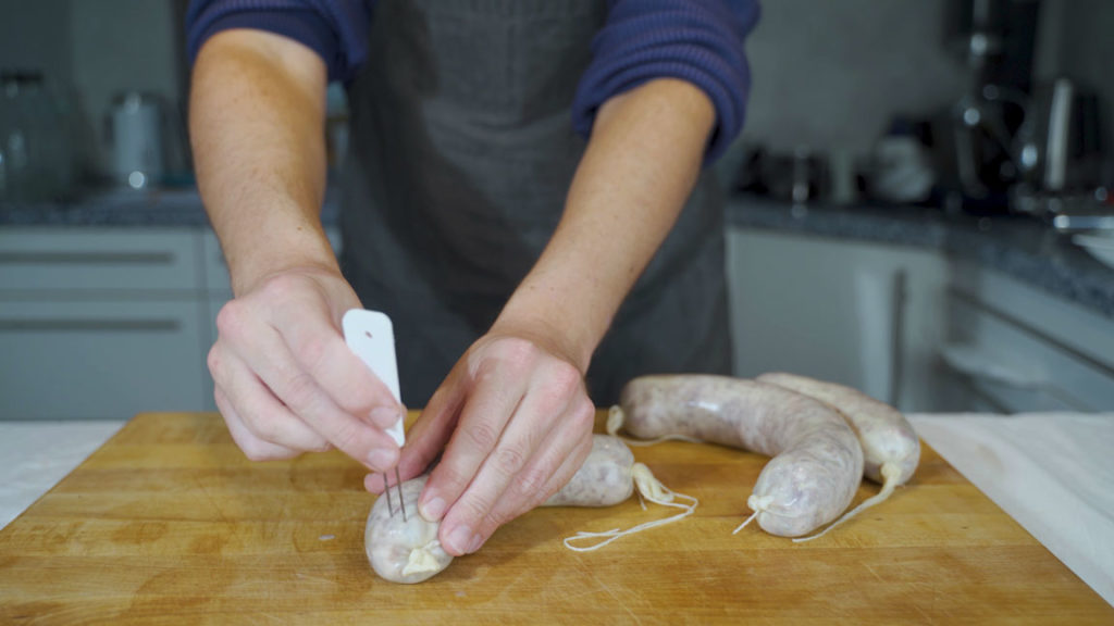 Removing air pockets from cotechino with a needle