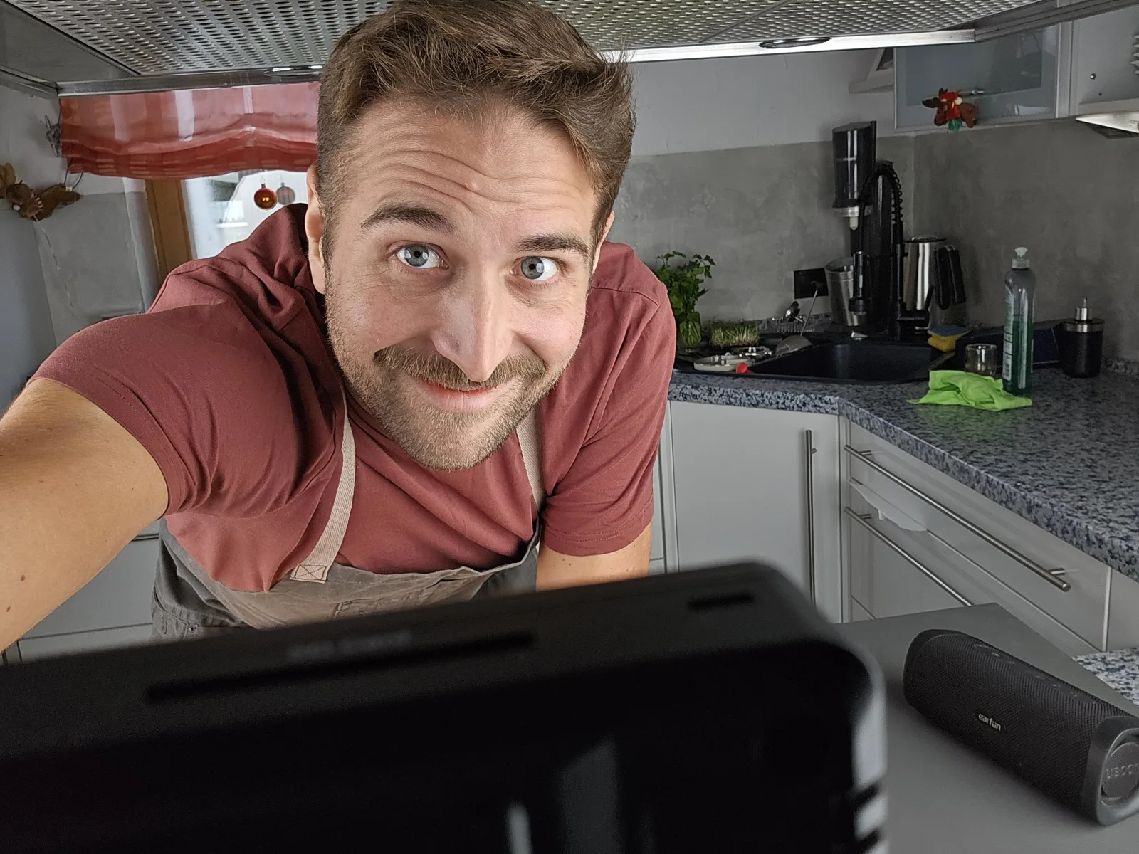 Daniel Wulf in his kitchen, looking curiously over the counter