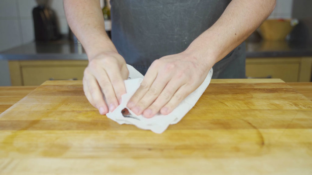 Patting cured salmon dry with a kitchen towel