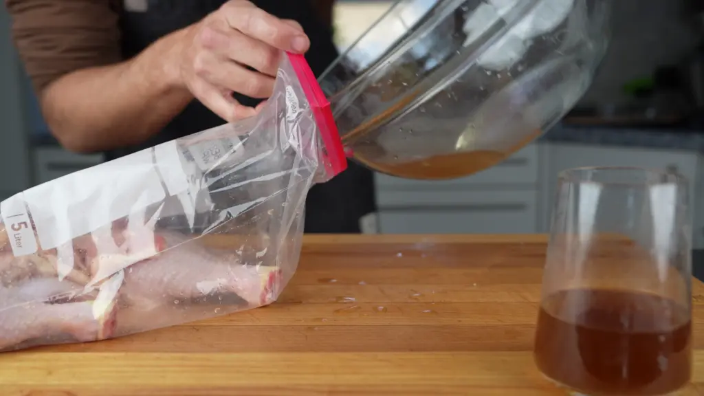Pouring the brine over the chicken legs in the bag