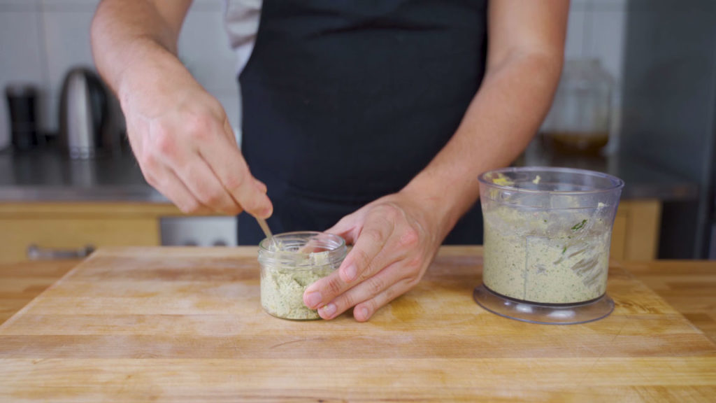 Filling a jar with mustard and dill spread