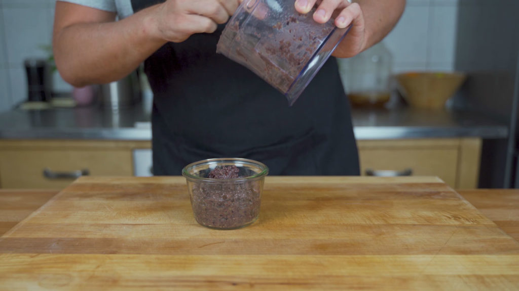 Filling a jar with tapenade