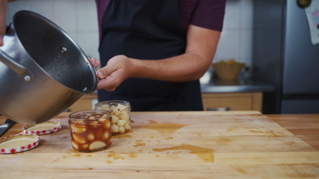 Pouring the pickling liquid over the garlic