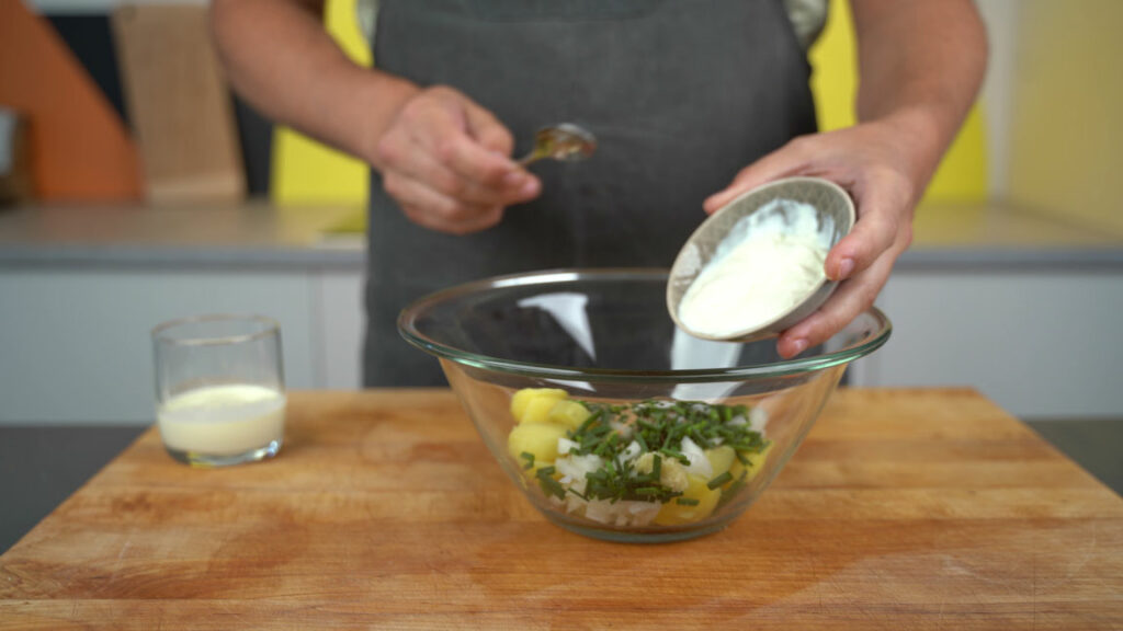 Adding cream and seasonings to the potatoes