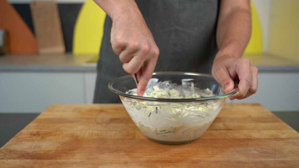 Mashing and mixing Erdäpfelkas with a fork