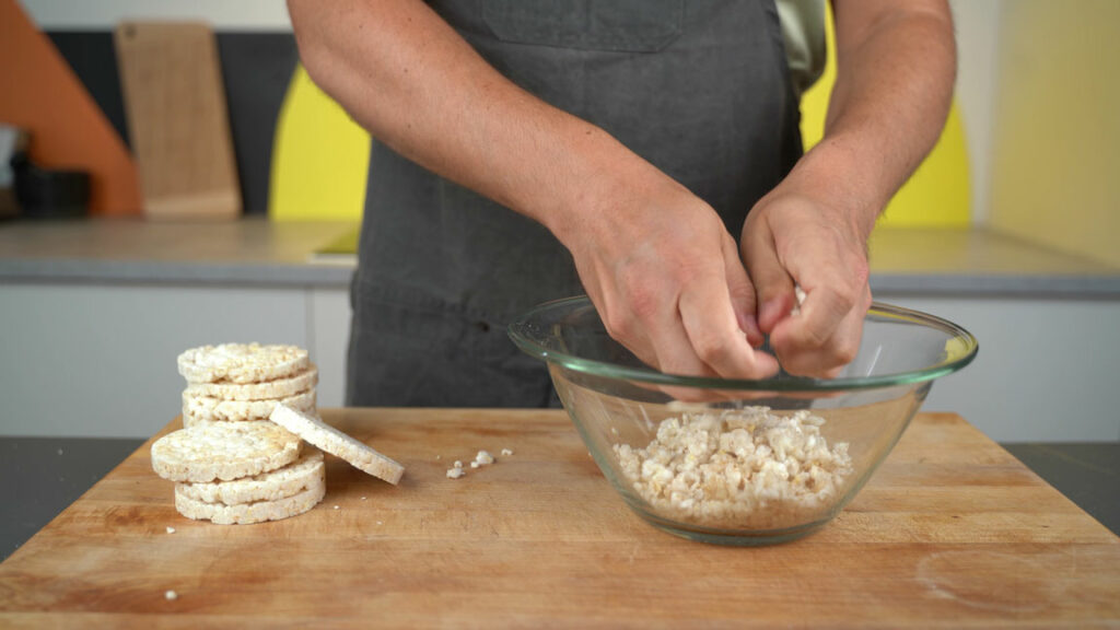 Crumbling rice cakes by hand for vegan Mett