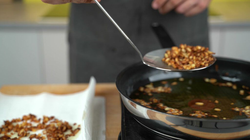 Removing the fried onions and apples from the fat