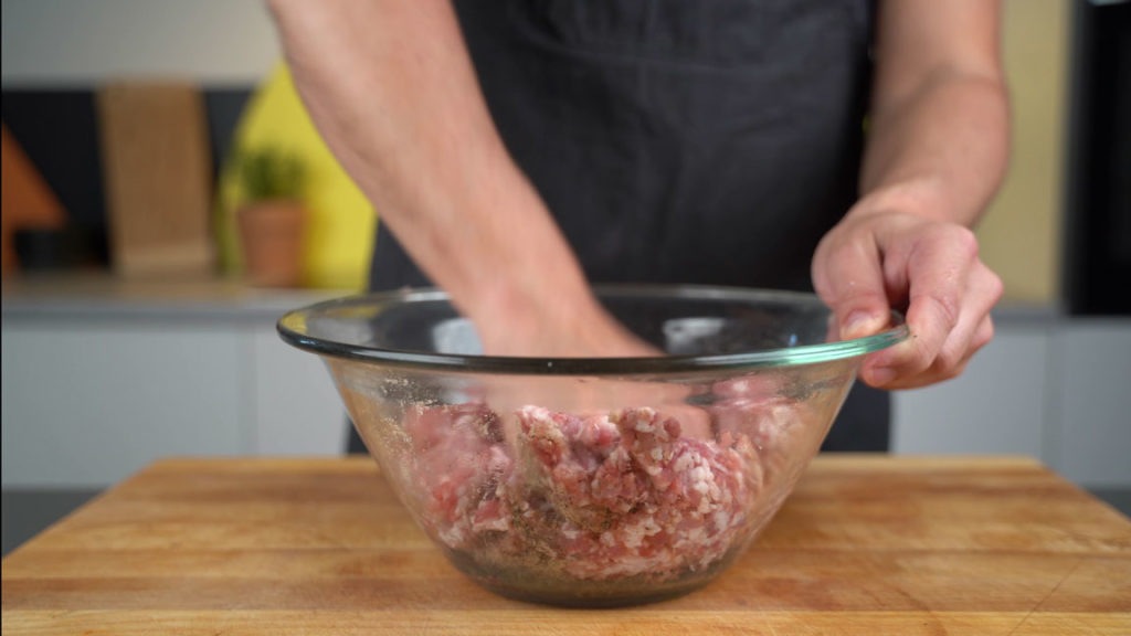 Mixing the ground spices into the sausage mixture
