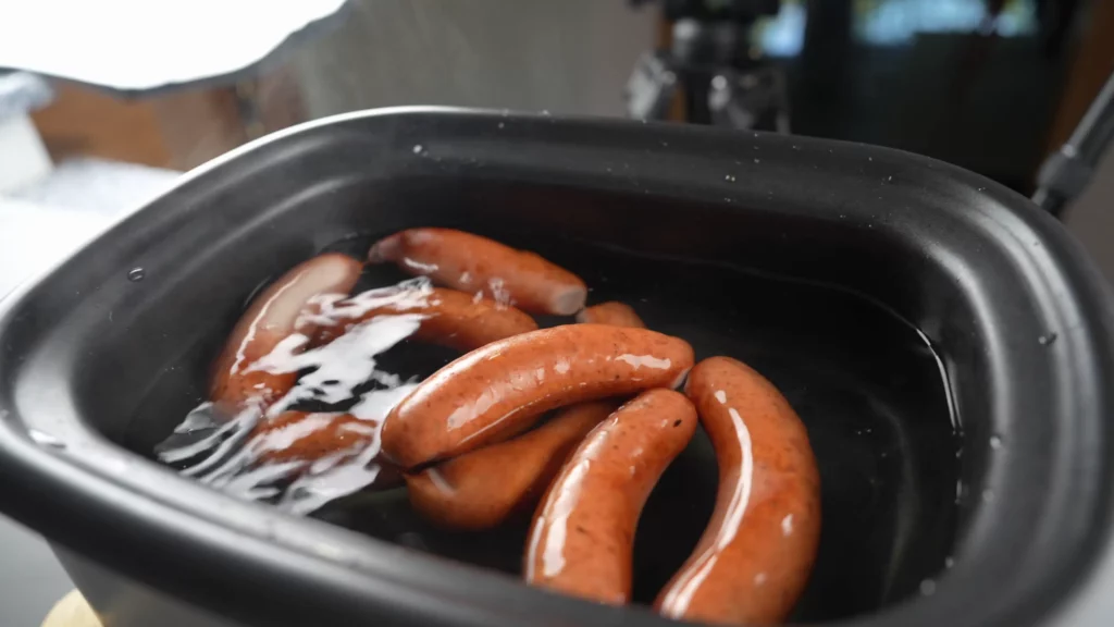 Poaching Swiss cervelat in water